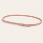Pink belt with a gold buckle on a light background