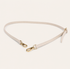 Ivory belt with gold hardware on a light beige background