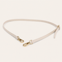 Ivory belt with gold hardware on a light beige background