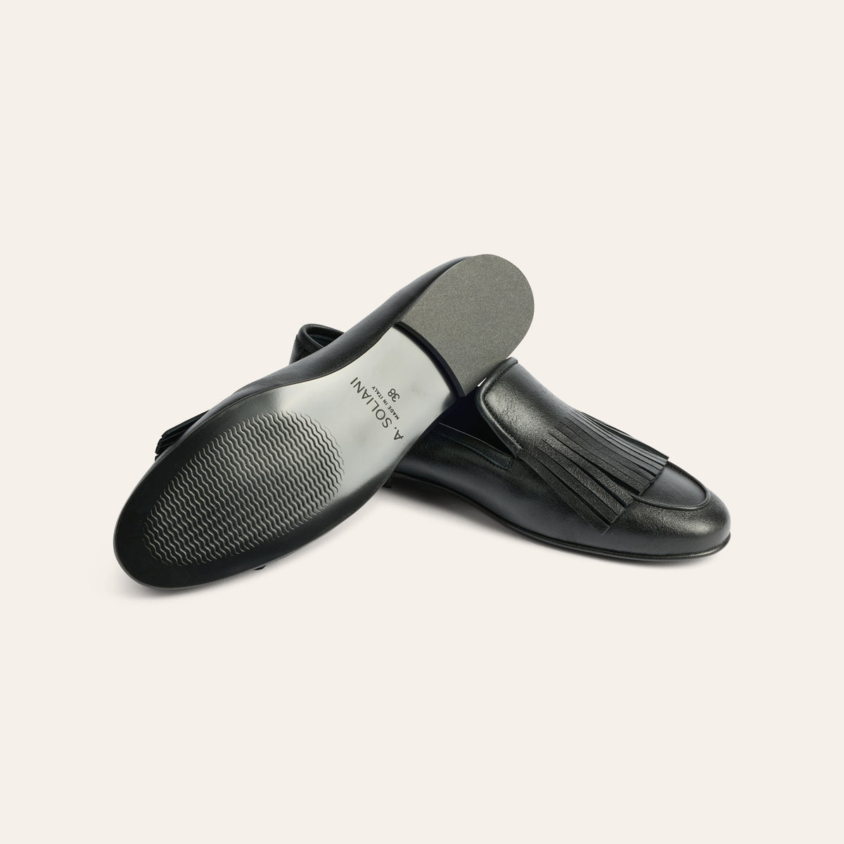 A pair of black leather slip-on loafers with fringe detailing, shown from the side and bottom on a light beige background. The brand name 'A SOLARI' is visible on the insole.